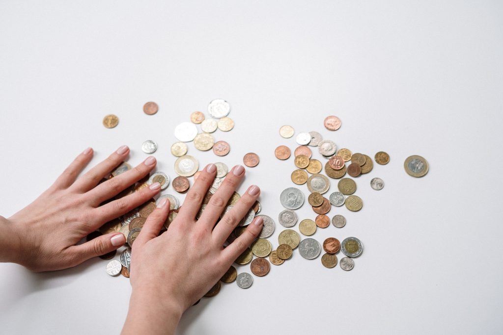 Two hands couting some coins for smart money tips.