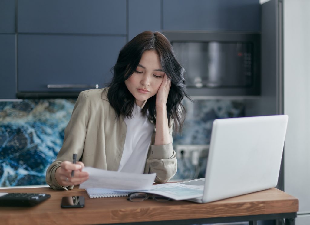 A woman worried about financial problems in front on her laptop