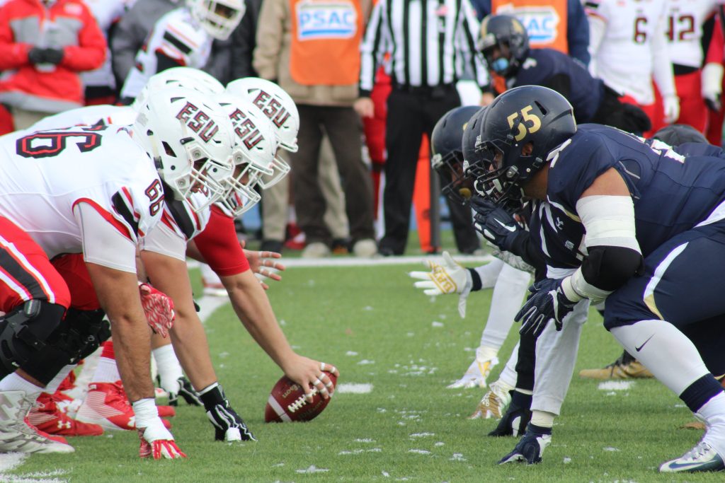 Players playing american football on the field, installment loans for short terms.