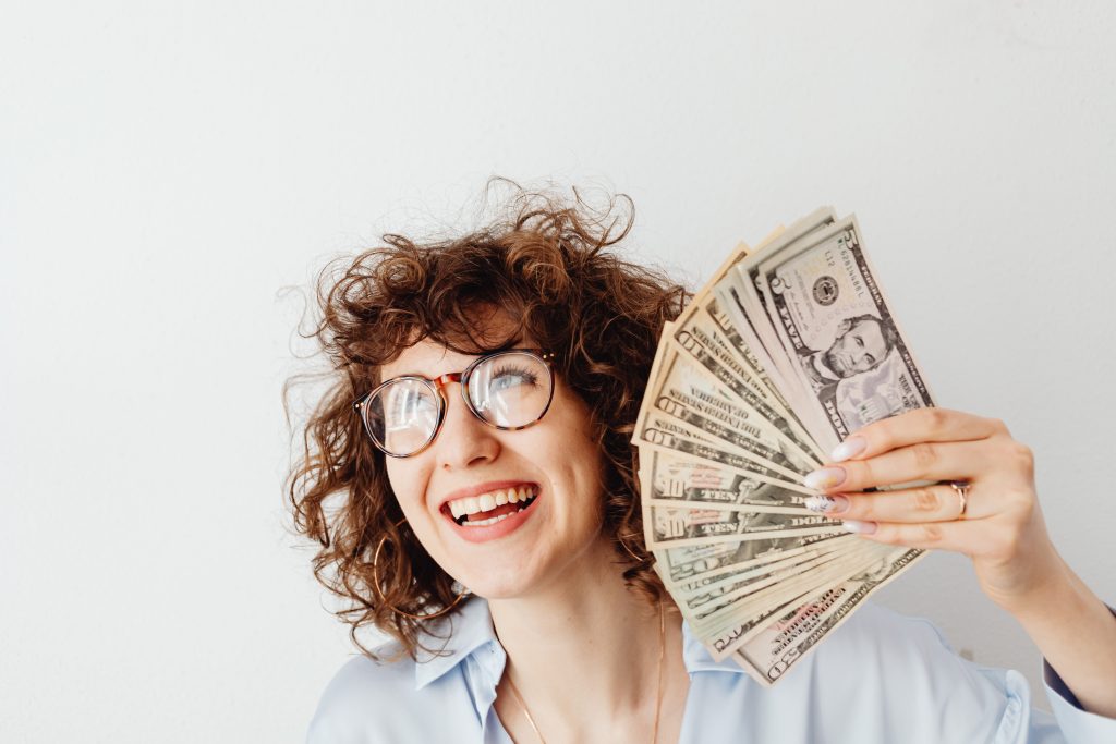 A happy woman with money in her hands.